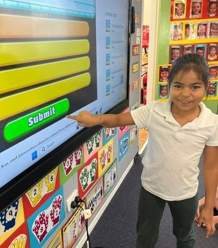 A student touching the screen on an interactive panel