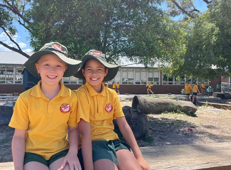 Two students sitting in the playground